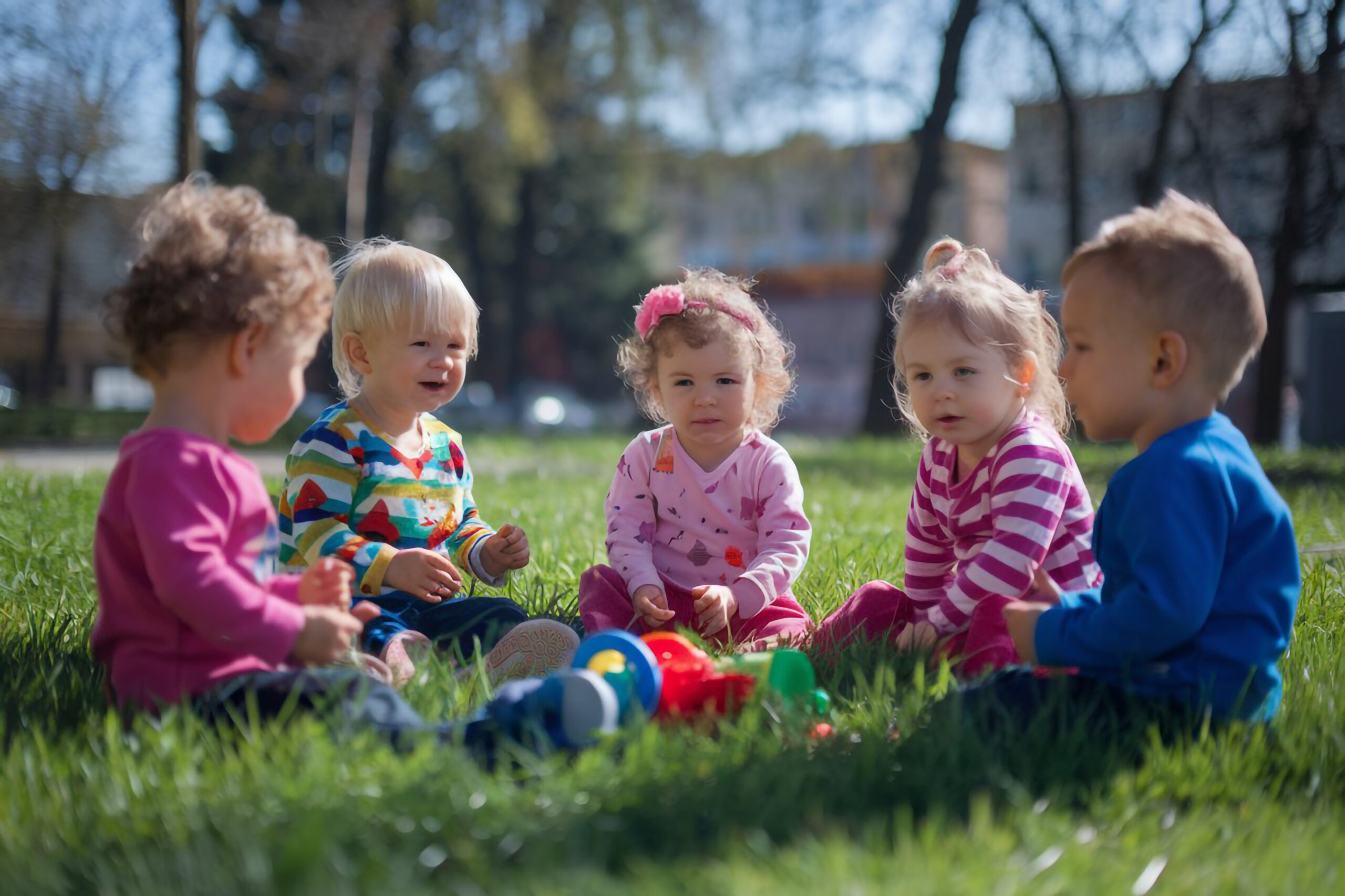 baby-is-sitting-grass-with-two-other-children
